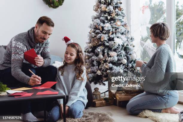father and daughter writing christmas cards - grant writer stock pictures, royalty-free photos & images