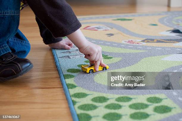 little boy plays with yellow car - 敷物 マット ストックフォトと画像