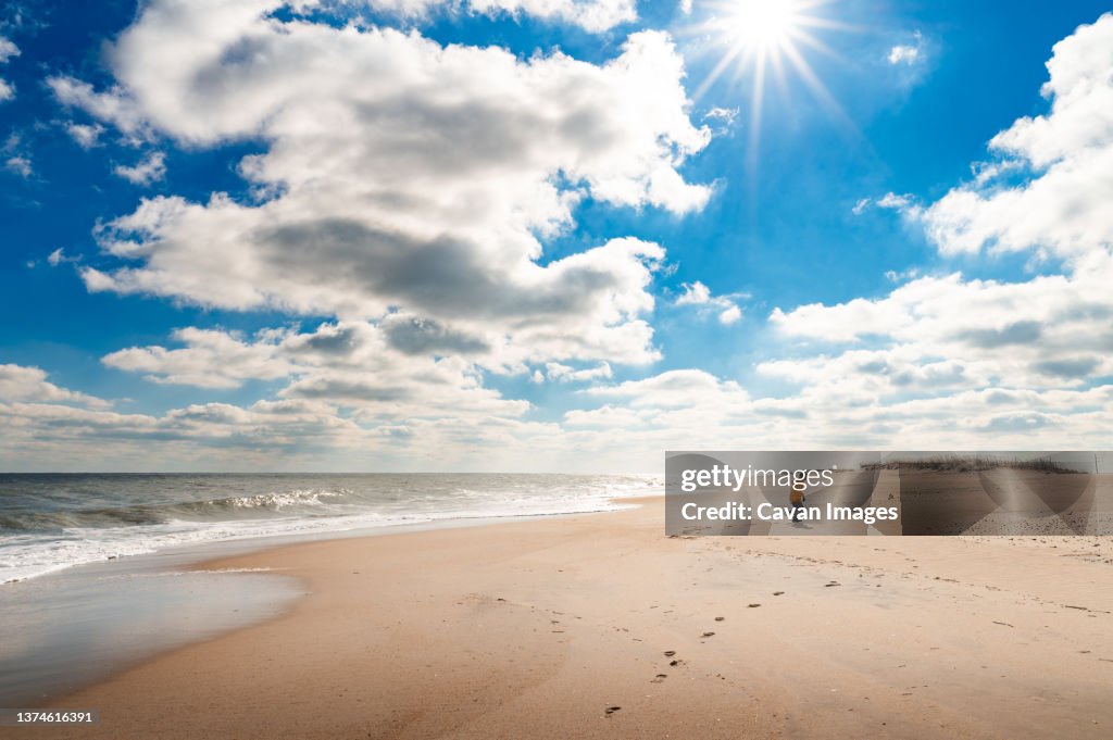 A boy running on the beach during a sunny day