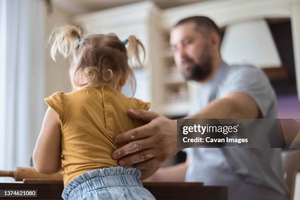 father and daughter prepare dough, father holds daughter - keep photos et images de collection