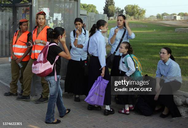 Israeli soldiers guard a bus stop as students wait for their school bus in the southern Israeli town of Sderot, 02 September 2007. The new school...