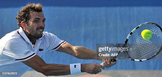 Julien Bennetteau of France reaches for a return against Kei Nishikori of Japan in their third round men's singles match on day six of the 2012...