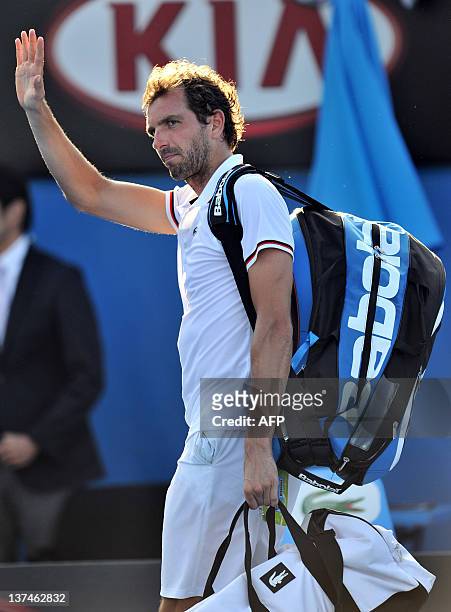 Julien Bennetteau of France waves goodbye following his loss to Kei Nishikori of Japan in their third round men's singles match on day six of the...