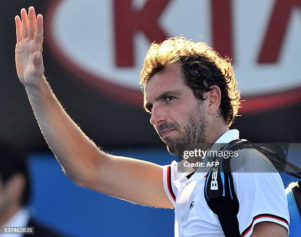 Julien Bennetteau of France waves goodbye following his loss to Kei Nishikori of Japan in their third round men's singles match on day six of the...