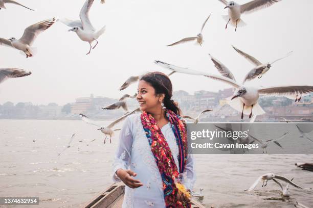 girl posing in varanasi surrounding by birds - varanasi corona stock pictures, royalty-free photos & images