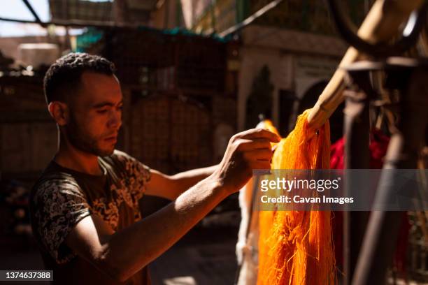 artisan hanging cotton thread to dry in workshop. - dye imagens e fotografias de stock