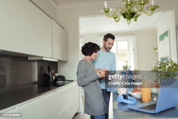 couple unloading grocery delivery at kitchen counter - unloading stock pictures, royalty-free photos & images