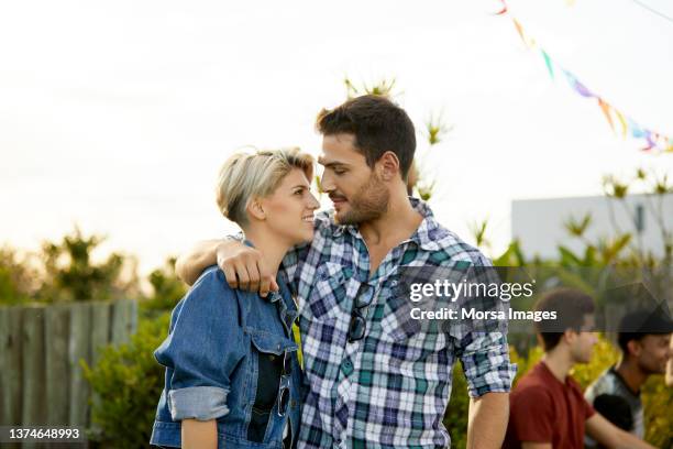 romantic couple in backyard at asado party - couple short hair stock pictures, royalty-free photos & images