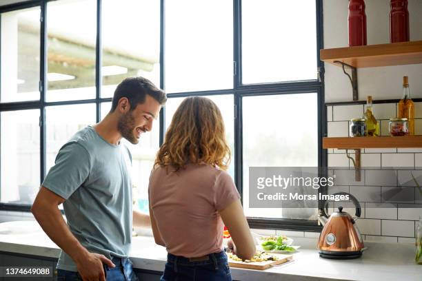 couple in kitchen during asado party - bbq chicken stock-fotos und bilder
