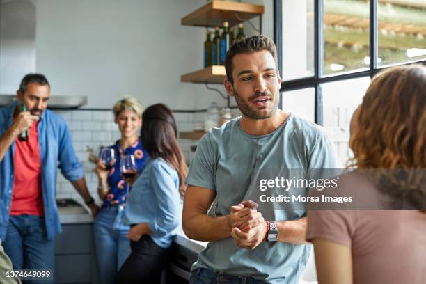 friends talking during social gathering at home - 30 39 years stock pictures, royalty-free photos & images