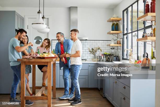 friends enjoying food in kitchen at home - argentina food imagens e fotografias de stock