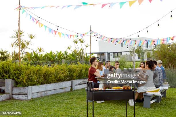 friends having dinner at table in backyard - family barbeque garden stock pictures, royalty-free photos & images