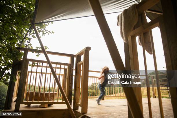 carefree girl running on wooden cabin balcony - carefree girl stock pictures, royalty-free photos & images