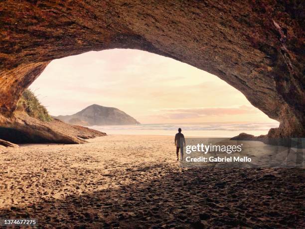 man walking towards the ocean wharariki beach - attraction ストックフォトと画像