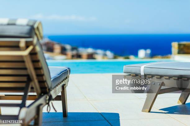 tumbonas junto a la piscina en apartamento de lujo - greek islands fotografías e imágenes de stock