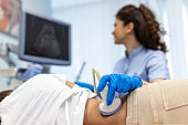 Doctor conducts ultrasound examination of patientv kidneys. Internal organs ultrasound concept. female's lower back diagnosis carried out with the use of an ultrasound