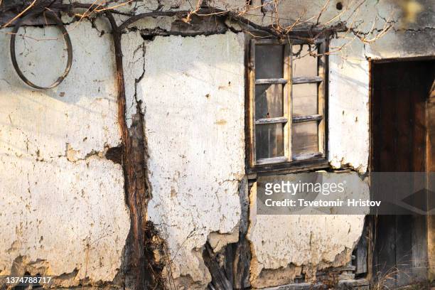 window on the old wall. the plaster on the wall is crumbling and cracks have appeared. - abandoned crack house stock pictures, royalty-free photos & images