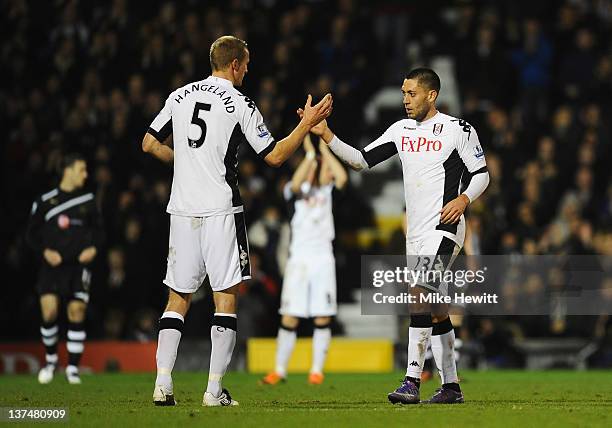 Clint Dempsey of Fulham is congratulated by Brede Hangeland after scoring a hat trick during the Barclays Premier League match between Fulham and...