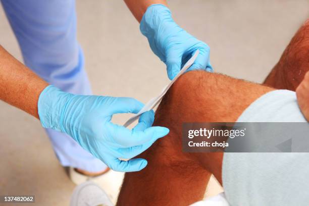 nurse is taking care of the wounded knee,changing bandage - applying plaster stock pictures, royalty-free photos & images