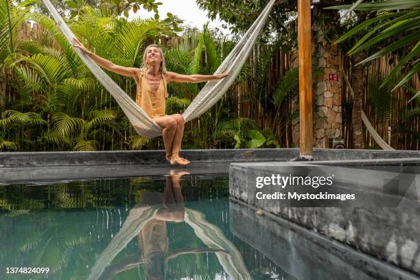 woman relaxing in an hammock by the pool - tulum mexico stock pictures, royalty-free photos & images