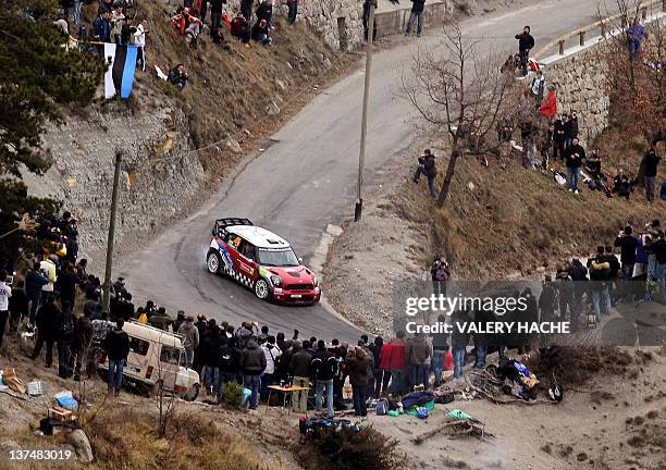 Members of the public look at Spanish driver Daniel Sordo steering his Mini Cooper during the fourth stage of the Monte-Carlo Rallye's 80th edition,...