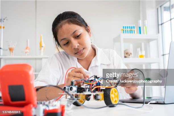 amused teen girl using tablet in the science studio - school students science stock pictures, royalty-free photos & images