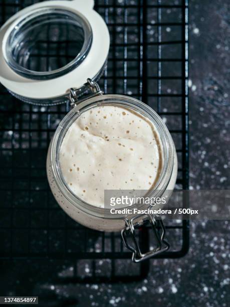 above shot of wheat sourdough starter in jar on table - grundnahrungsmittel stock-fotos und bilder