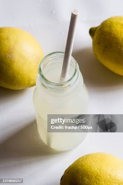 close-up of drink with lemons and juice with reusable paper straw on table - straw ストックフォトと画像