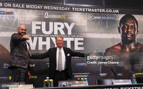 Tyson Fury faces on with a picture of Dilian Whyte as Frank Warren, Promoter pretends to separate them during the Tyson Fury v Dillian Whyte press...