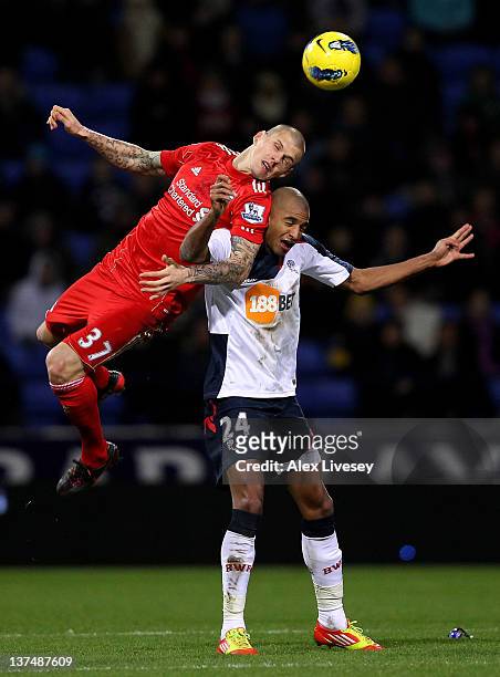 David Ngog of Bolton Wanderers tangles with Martin Skrtel of Liverpool during the Barclays Premier League match between Bolton Wanderers and...