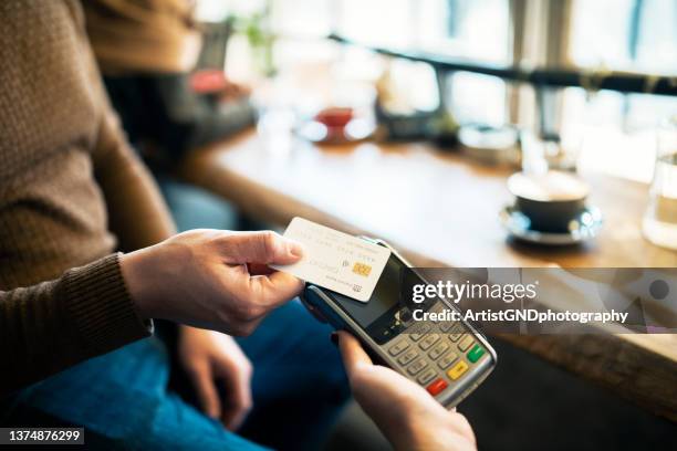hombre haciendo el pago con tarjeta. - charging fotografías e imágenes de stock