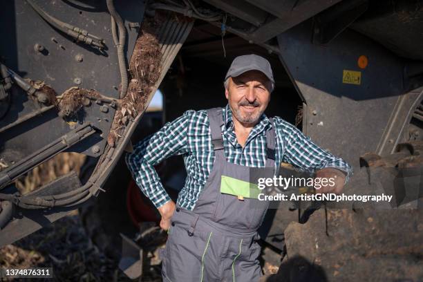 portrait of senior mechanic repairing a combine. - tractor repair stock pictures, royalty-free photos & images