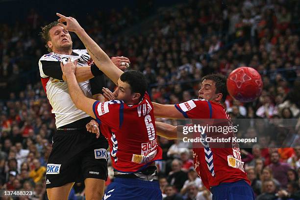 Marko Vujin and Momir Ilic of Serbia defend against Lars Kaufmann of Germany during the Men's European Handball Championship second round group one...