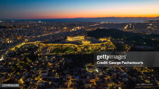 aerial photo of the illuminated parthenon at the acropolis of athens, greece and beautiful sunset colors - athens democracy stock pictures, royalty-free photos & images