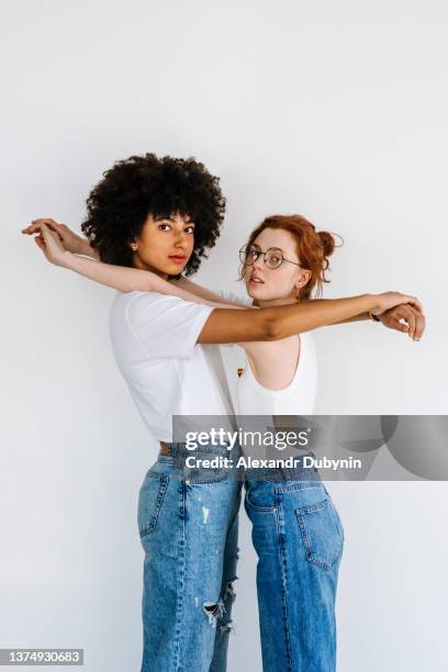 couple lesbian women standing together and hugging indoors on white background. lgbt concept - couples studio portrait stock-fotos und bilder