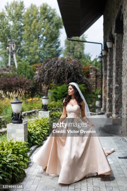 elegant young bride walks to the garden - bride veil stock pictures, royalty-free photos & images