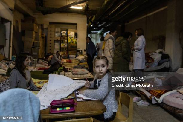 Girl draws at a table set up in the bomb shelter at the Okhmadet Children's Hospital on March 01, 2022 in Kyiv, Ukraine. Russian forces continued...