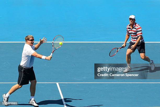 Yevgeny Kafelnikov of Russia plays a backhand with Wayne Ferreira of Russia in their Legends double's match against Guy Forget and Henri Leconte of...