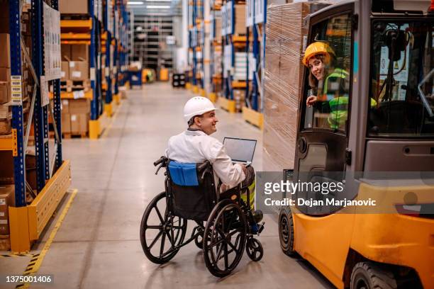 menschen mit behinderung arbeiten im palettenlager - man wheel chair stock-fotos und bilder