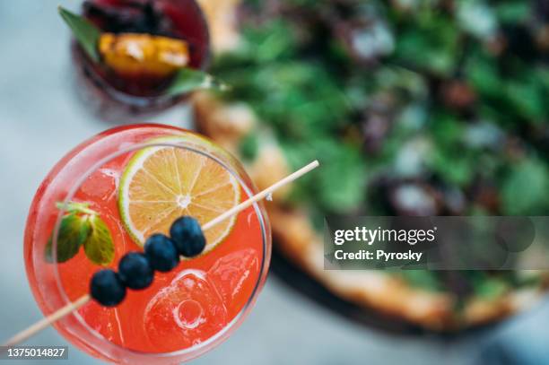 directly above the red cocktail next to the pizza - aperitief stockfoto's en -beelden