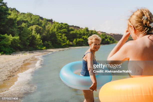 mature female friends at the beach - old woman in swimsuit stock pictures, royalty-free photos & images