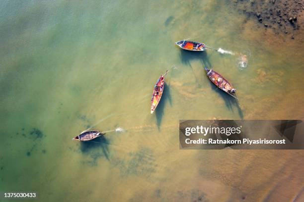 aerial view of long tail boat anchored during low tide. - longtail boat stock pictures, royalty-free photos & images