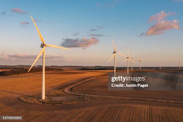 drone view of a wind farm. multiple wind turbines - energia eolica foto e immagini stock