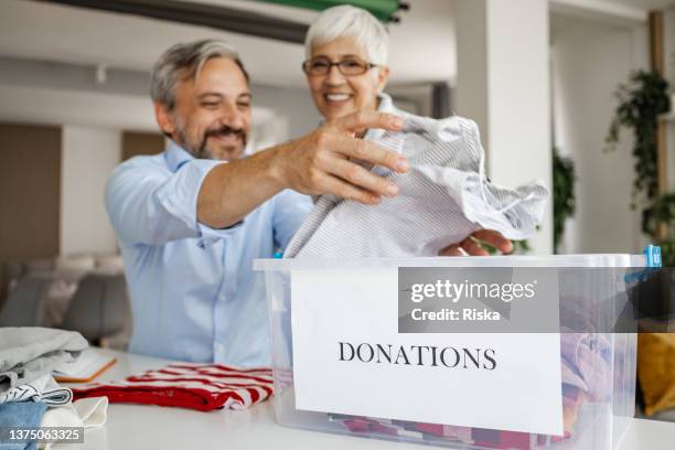 casal preparando caixa de doação de roupas e itens pessoais - selfless - fotografias e filmes do acervo