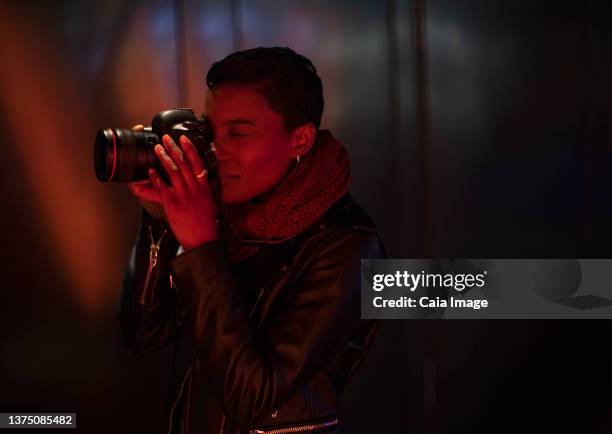 young woman using digital camera in dark red light - photographer stock pictures, royalty-free photos & images