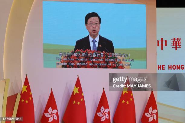 Hong Kong chief executive John Lee is seen on a giant screen as he speaks during an event celebrating the 26th anniversary of the city's handover...