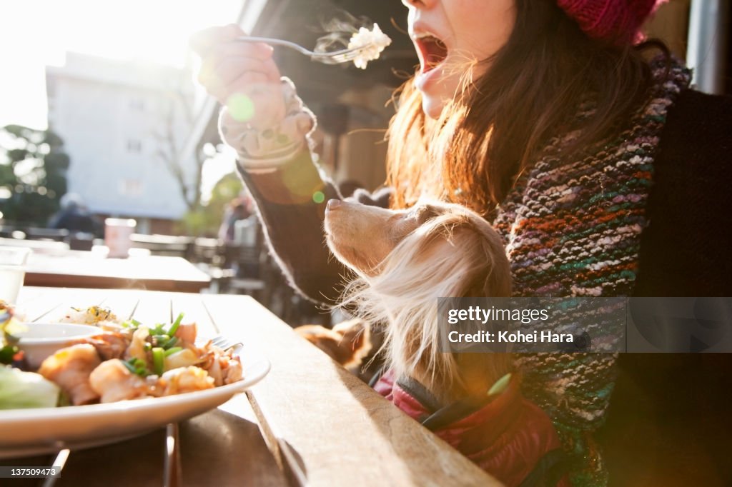Woman and dog sitting on the patio at cafe