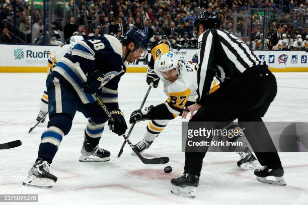 Linesman Travis Toomey drops the puck on a face-off for Sidney Crosby of the Pittsburgh Penguins and Boone Jenner of the Columbus Blue Jackets during...