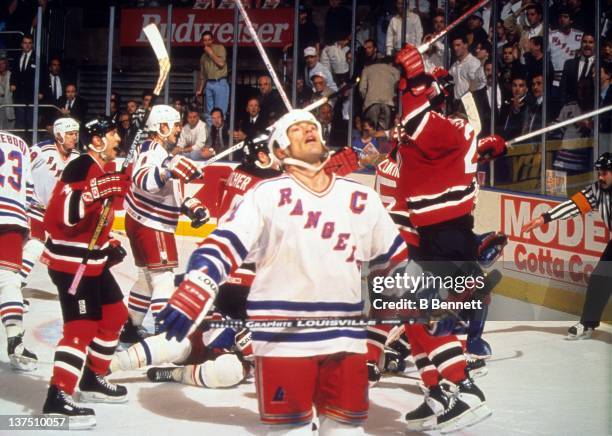 Mark Messier of the New York Rangers looks dejected as the New Jersey Devils celebrate when Valeri Zelepukin of the Devils scored the tying goal with...