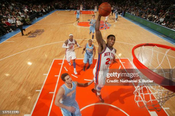 Iman Shumpert of the New York Knicks goes in for a dunk as Danilo Gallinari of the Denver Nuggets watches during the game on January 21, 2012 at...